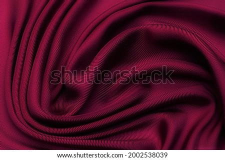 Cherry twill silk fabric in artistic layout. Texture, background, pattern.