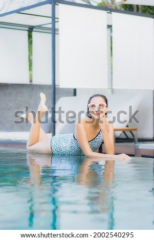 Portrait beautiful young asian woman relax smile leisure around outdoor swimming pool nearly sea beach in Travel vacation