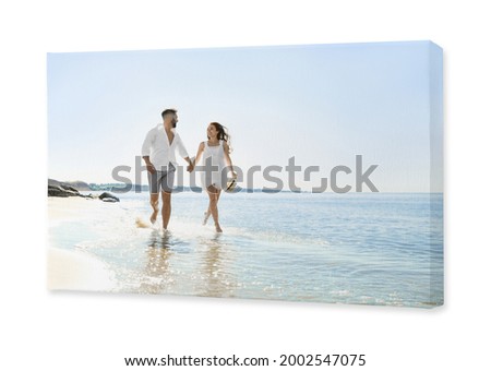 Photo printed on canvas, white background. Happy young couple running on beach near sea