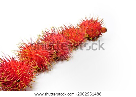 Red rambutan arranged on a white background