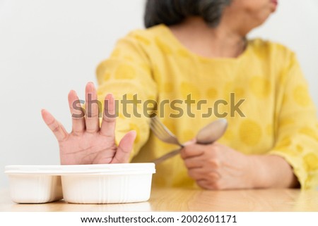 Unhappy Asian senior woman anorexia and say no to ready meals, Elderly home alone and bored food and no appetite Royalty-Free Stock Photo #2002601171