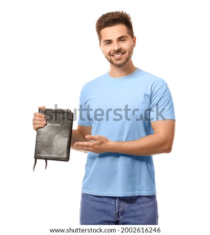 Young man with Bible on white background
