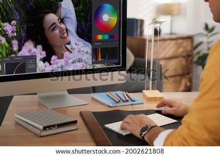Professional retoucher working on computer at table, closeup
