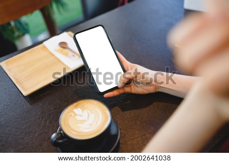 Close up of woman using mobile blank smart phone and credit card sending massages in the coffee shop