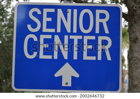 A blue sign instructs Senior Center ahead with an arrow pointing up.