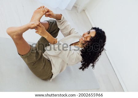 Beautiful woman brunette engaged in yoga asana gymnastics flexibility
