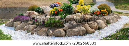panorama round flower bed of flowers and stones. Royalty-Free Stock Photo #2002668533