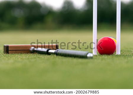 croquet mallet, wicket and colorful balls on a green lawn Royalty-Free Stock Photo #2002679885