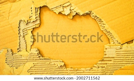Frame made of abstract yellow colored old damaged torn paper, cardboard pattern texture background