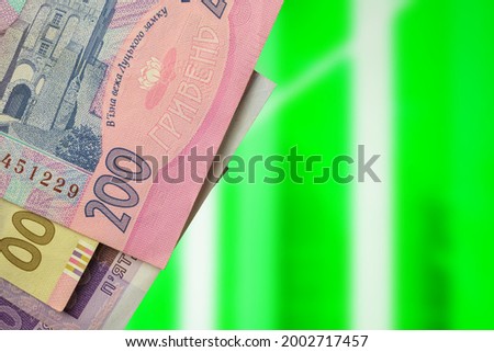 Ukrainian hryvnia value rise concept background, money banknotes on green stock chart photo