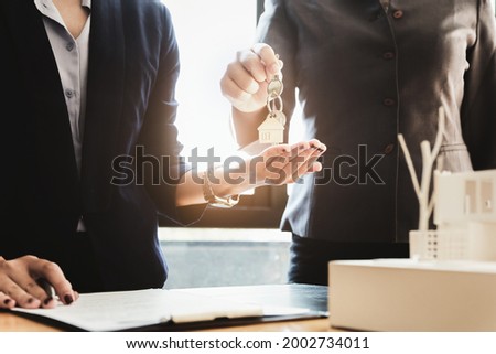 Real estate agents agree to buy a home and give keys to clients at their agency's offices. Concept agreement.