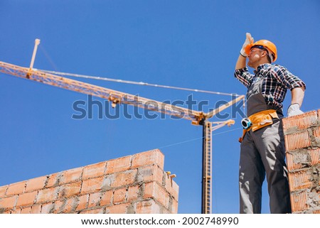 Young craftsman building a house