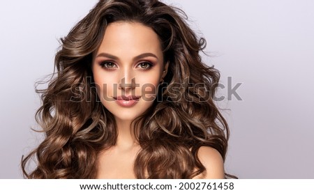 Beautiful smiling woman with long wavy hair .  Girl curly hairstyle   Beauty ,makeup and cosmetics . 