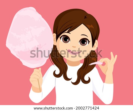 Cute little girl eating delicious tasty cotton candy floss picking on pink background