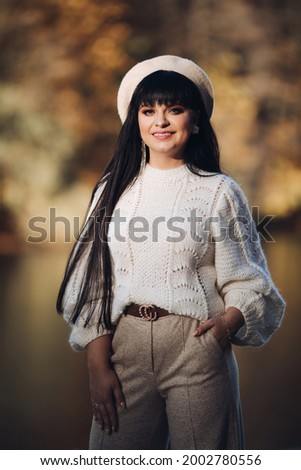 Picture of attractive woman goes for a walk near the river and thinks about something