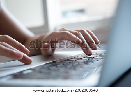 Closeup image of business woman's hands working and typing on laptop keyboard on office table, surfing the internet, telecommuting, online business concept, blogger blogging new content via laptop
