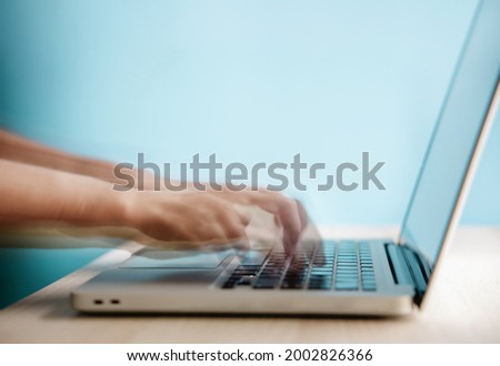 Word of Mouth, Power on the Internet Concept. Motion Blurred image of Hand Using Computer Laptop Keyboard on Desk against the wall. Marketing Strategy. Quick Spread of Text or Speech via Technology Royalty-Free Stock Photo #2002826366