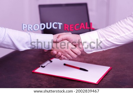 Text caption presenting Product Recall. Conceptual photo request to return the possible product issues to the market Two Professional Well-Dressed Corporate Businessmen Handshake Indoors