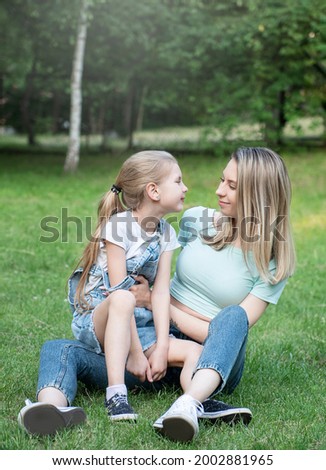 Picture of woman and child sitting on the grass and having fun together