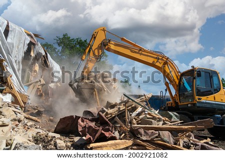 Process of demolition of old building dismantling. Excavator breaking house. Destruction of dilapidated housing for new development Royalty-Free Stock Photo #2002921082