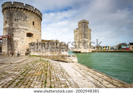 Entrance of the old harbor of La Rochelle in France, with the Tour de la Chaine at the foreground and Tour Saint-Nicolas at the background, Nouvelle Aquitaine region, department of Charente-Maritime
