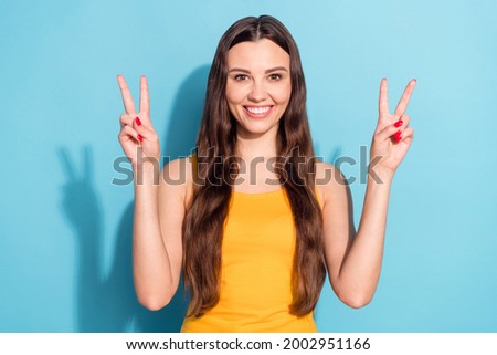 Photo portrait girl showing v-sign gesture peace sign both hands isolated pastel blue color background
