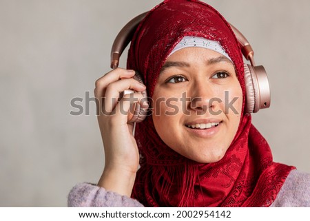 Muslim woman listening to music Royalty-Free Stock Photo #2002954142