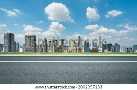Side view of asphalt road highway with modern city skyline Royalty-Free Stock Photo #2002957133
