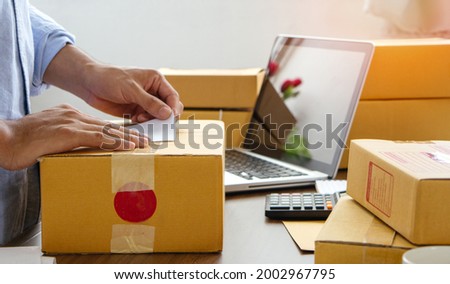Young business man prepare parcel box of product for deliver to customer. Online selling.