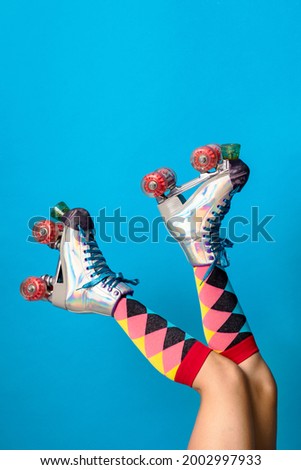 Feminine legs in a roller skates shoes with blue background