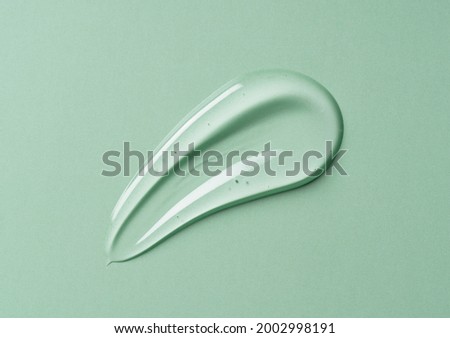 Transparent gel drop on green background. Liquid gel cosmetic stain texture. Beauty serum drop. Transparent skin care product sample. Royalty-Free Stock Photo #2002998191