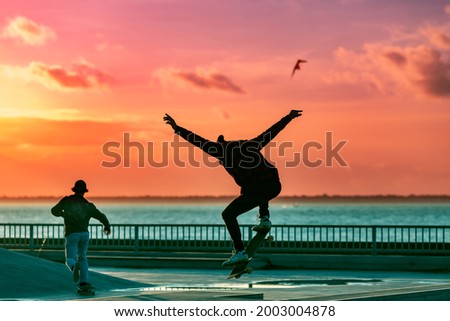 Silhouette of a skateboarder jumping in a skatepark.