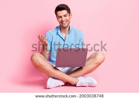 Photo of handsome guy make video call meeting talk look pc screen wear blue shirt isolated on pink color background