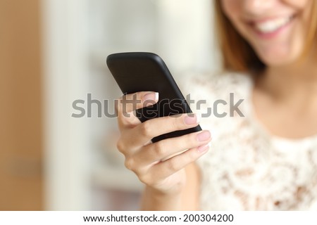 Close up of a woman hand using a smart phone at home with her smile in the background        