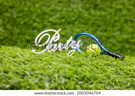 Tennis Party with racket and ball are on green grass