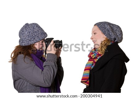 Two young women in winter clothes taking photos of each other, isolated, copy space