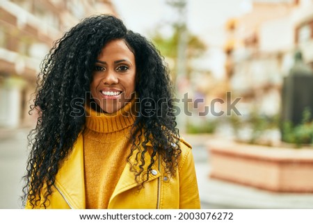 Middle age african american woman smiling happy standing at the city.