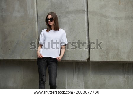 Girl or woman wearing white blank t-shirt with space for your logo, mock up or design in casual urban style