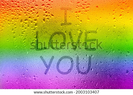 The inscription on the sweaty glass. The word I LOVE YOU written on glass with rainbow. LGBT rainbow