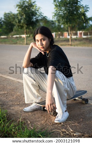 Beautiful girl sitting on skateboard, street and portrait photography