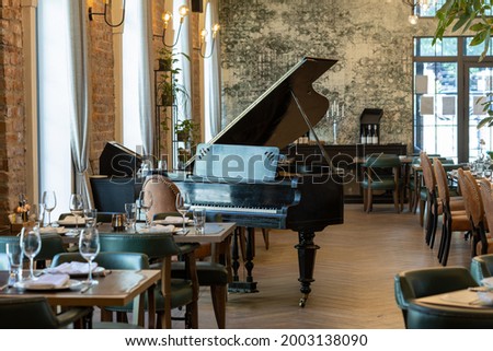 Interior of a modern hotel cafe restaurant with piano