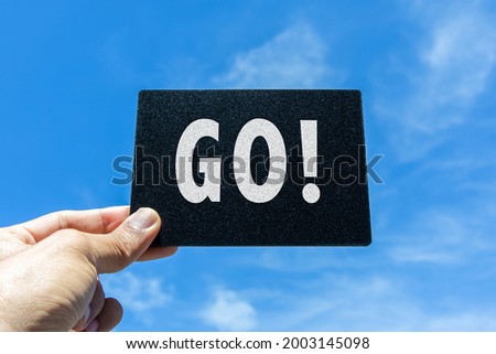"GO!" card with clouds and sky background.