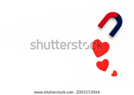 Magnetic love concept. Horseshoe magnet with heart shapes