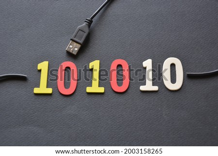 Shot of wooden numbers that make up a binary number that is part of the usb cable