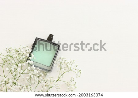 Top view of elegant perfume bottle with flowers over wooden white background. Cosmetics, fragrance and perfumery concept Royalty-Free Stock Photo #2003163374