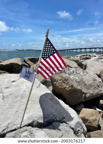 American flag on rocky jetties at Norriego Point Florida with Gulf of Mexico water background