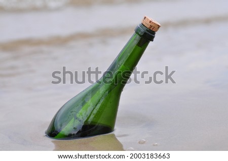 Closeup of message in bottle on beach