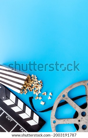 Layout of film reel with popcorn and clapperboard. Cinema concept
