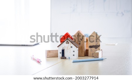 Conceptual image of property investment group of home on white table in the business meeting room