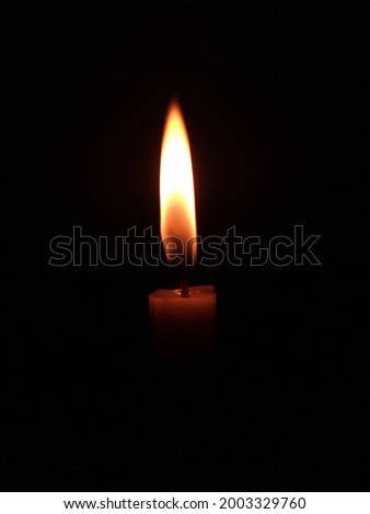 Burning candle in the darkness 